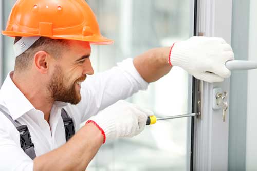 Réparateur de serrure sourant portant un casque de chantier