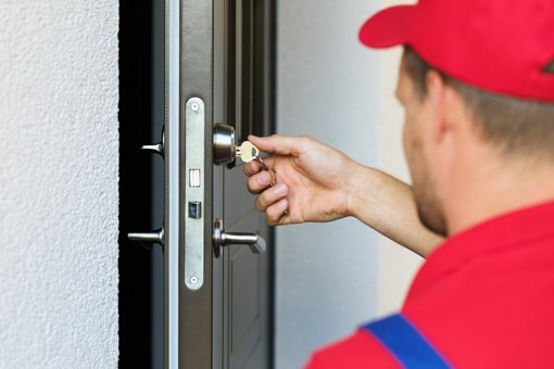 Artisan serrurier vérifiant l'ouverture d'une porte et le fonctionement de la serrure