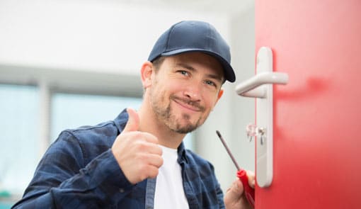 Photo d'un serrurier souriant durant son dépannage