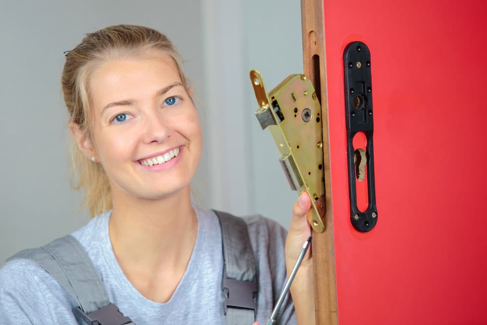 Femme souriante en train d'effectuer un changement de serrure